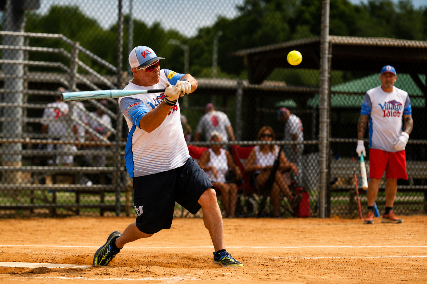 Player driving a softball into play during tournament action