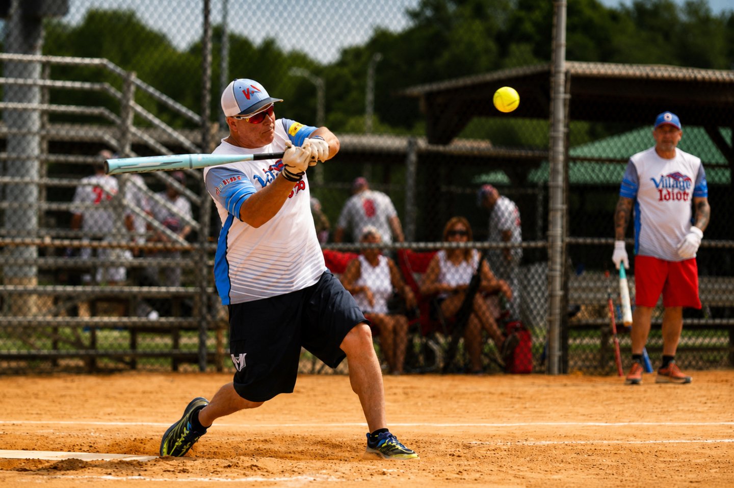 Player driving a softball into play during tournament action